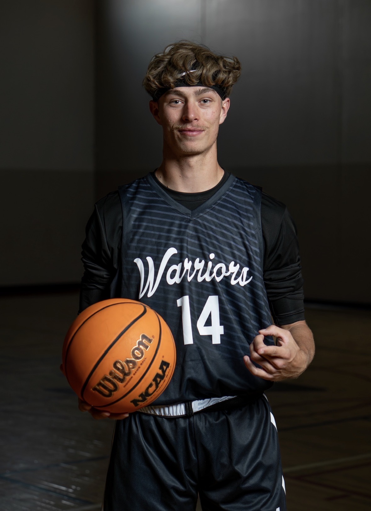 Gabe Montoya wearing his number 14 Colorado Warriors uniform and holding a basketball