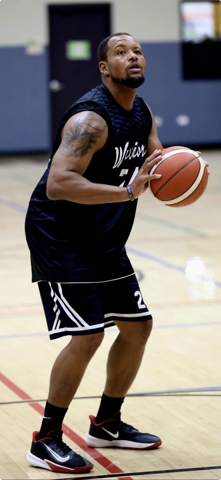 Raymond Johnson holding a basketball in his Colorado Warriors uniform