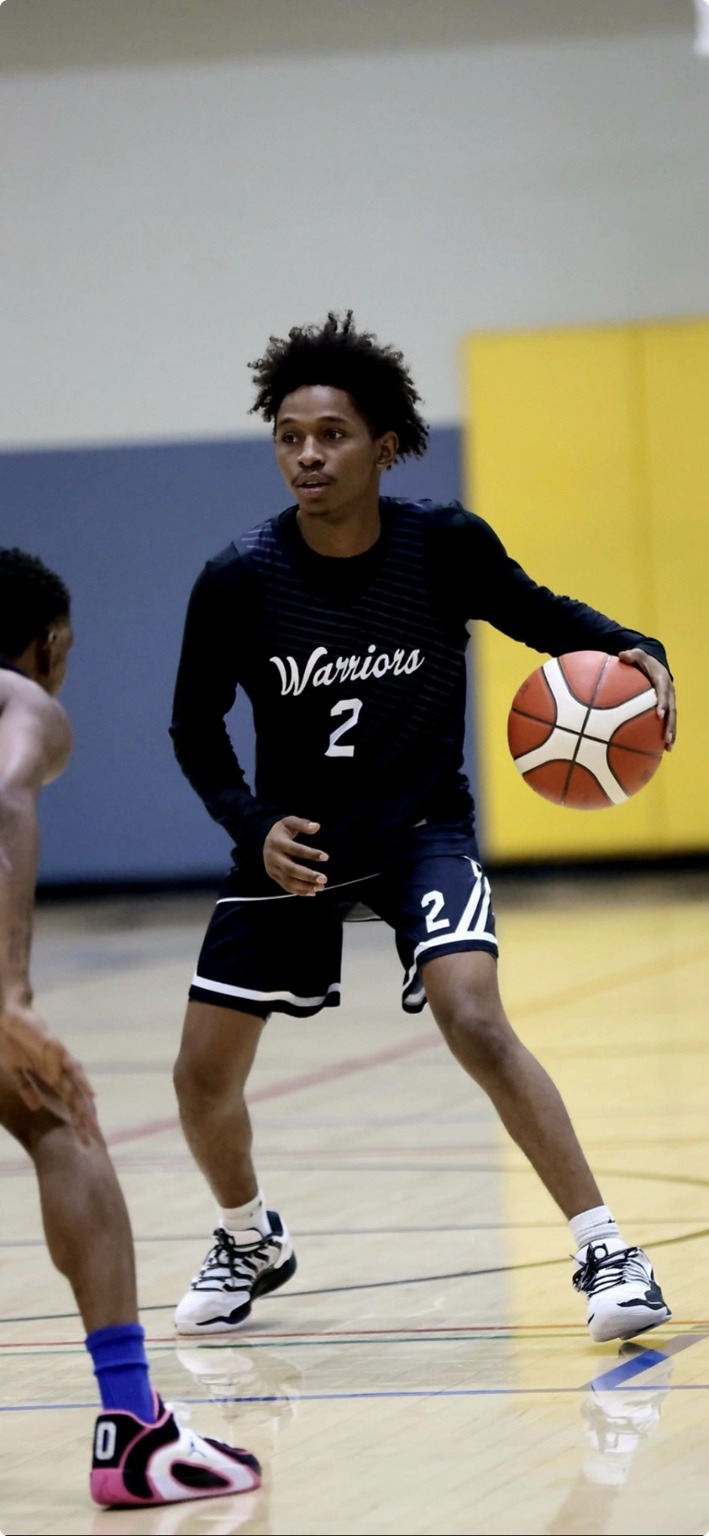 Tiquan Williams dribbling a basketball in his number 2 Colorado Warriors uniform